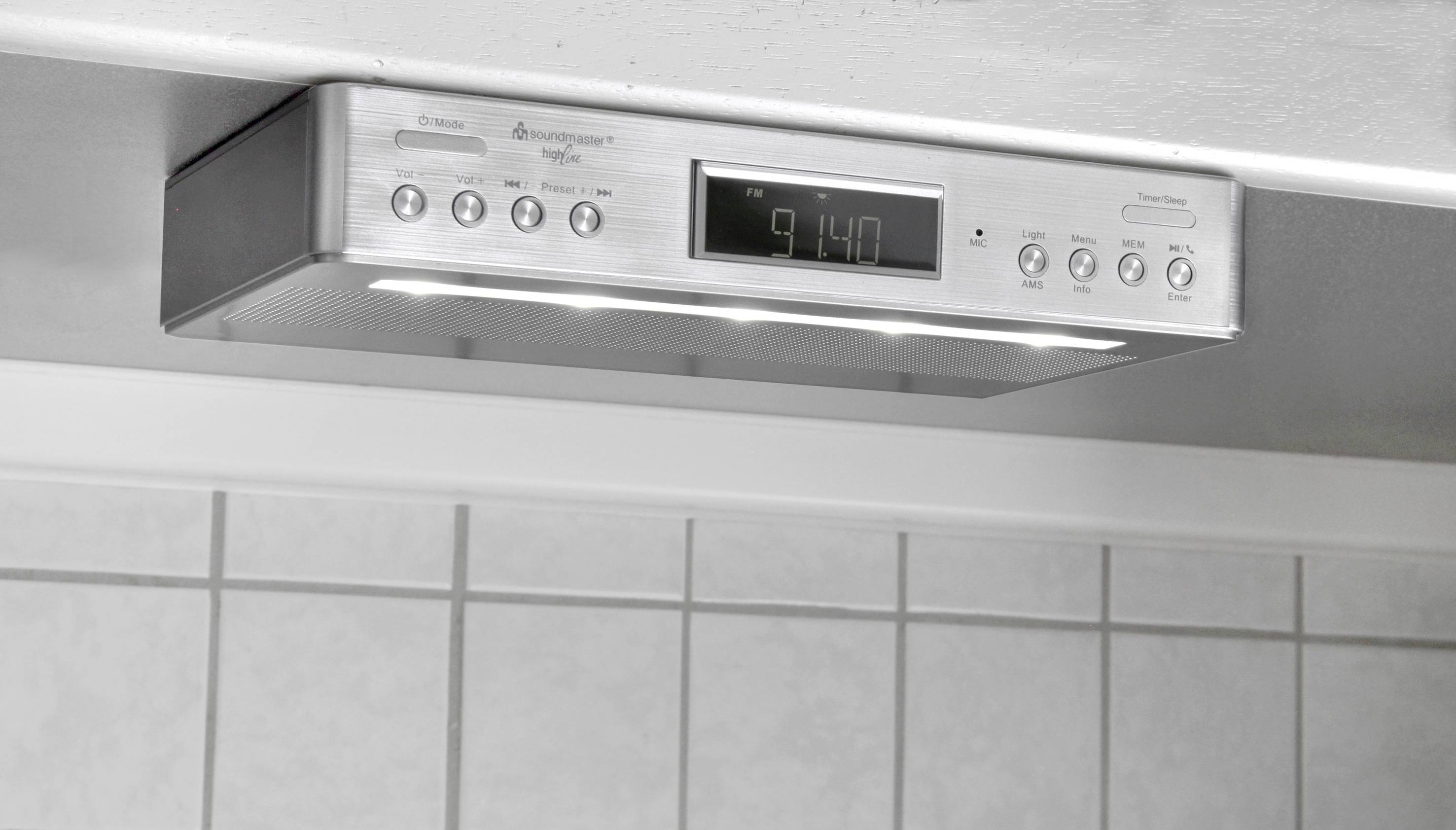 Digitální podřadní kuchyňské hodiny s několika tlačítky a LED světly, zobrazující čas 9:14. Upevněné pod kuchyňskou skříňkou nad obklady.