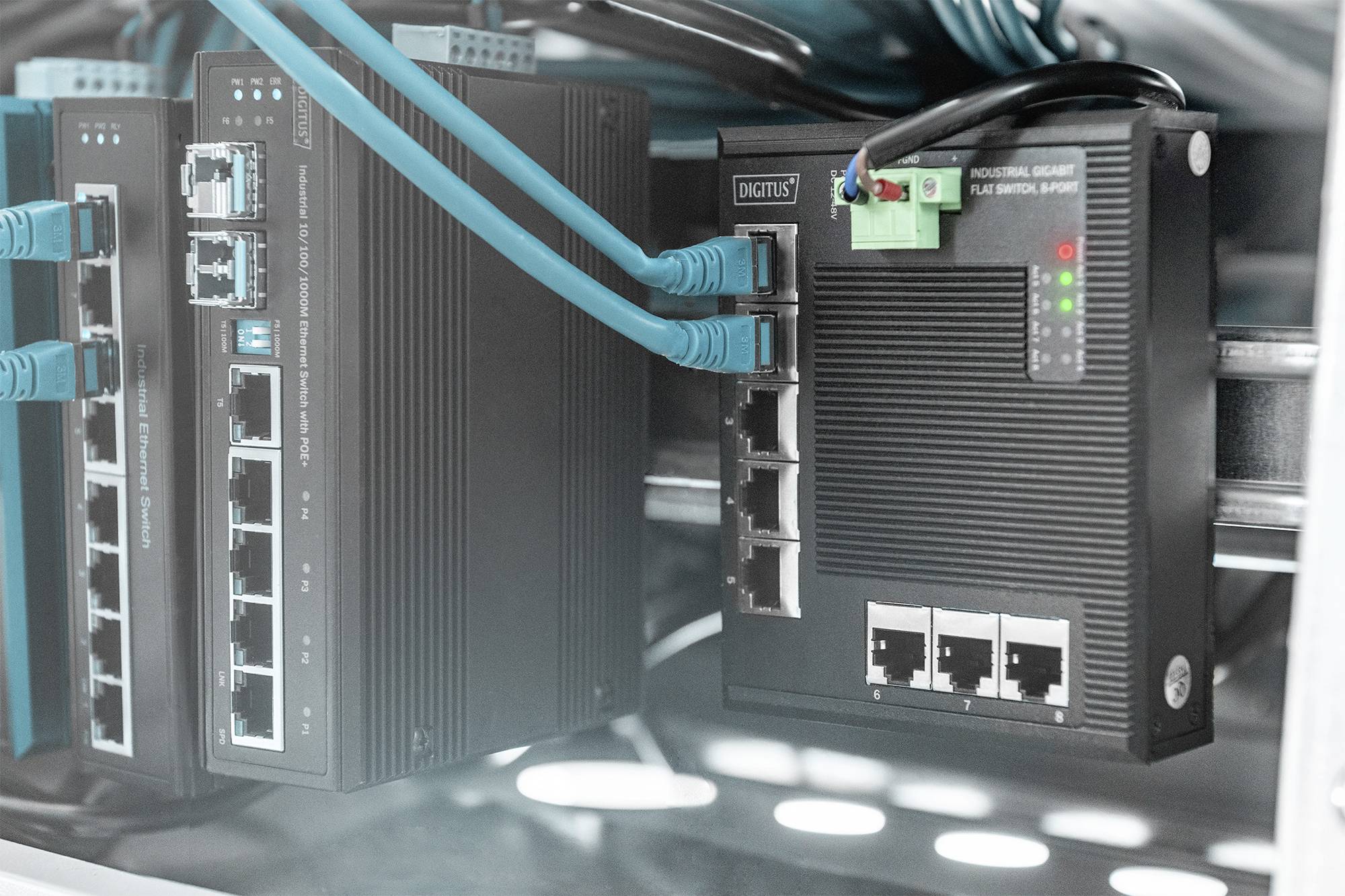 Síťová zařízení s několika kabelovými a připojovacími spoji v serverovně. LED diody svítí na přední straně zařízení.