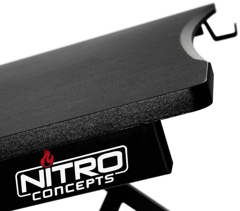 Stolní nástavec s vyvýšenou černou deskou. Pod ní je logo 'Nitro Concepts'. Ideální pro ergonomické účely.