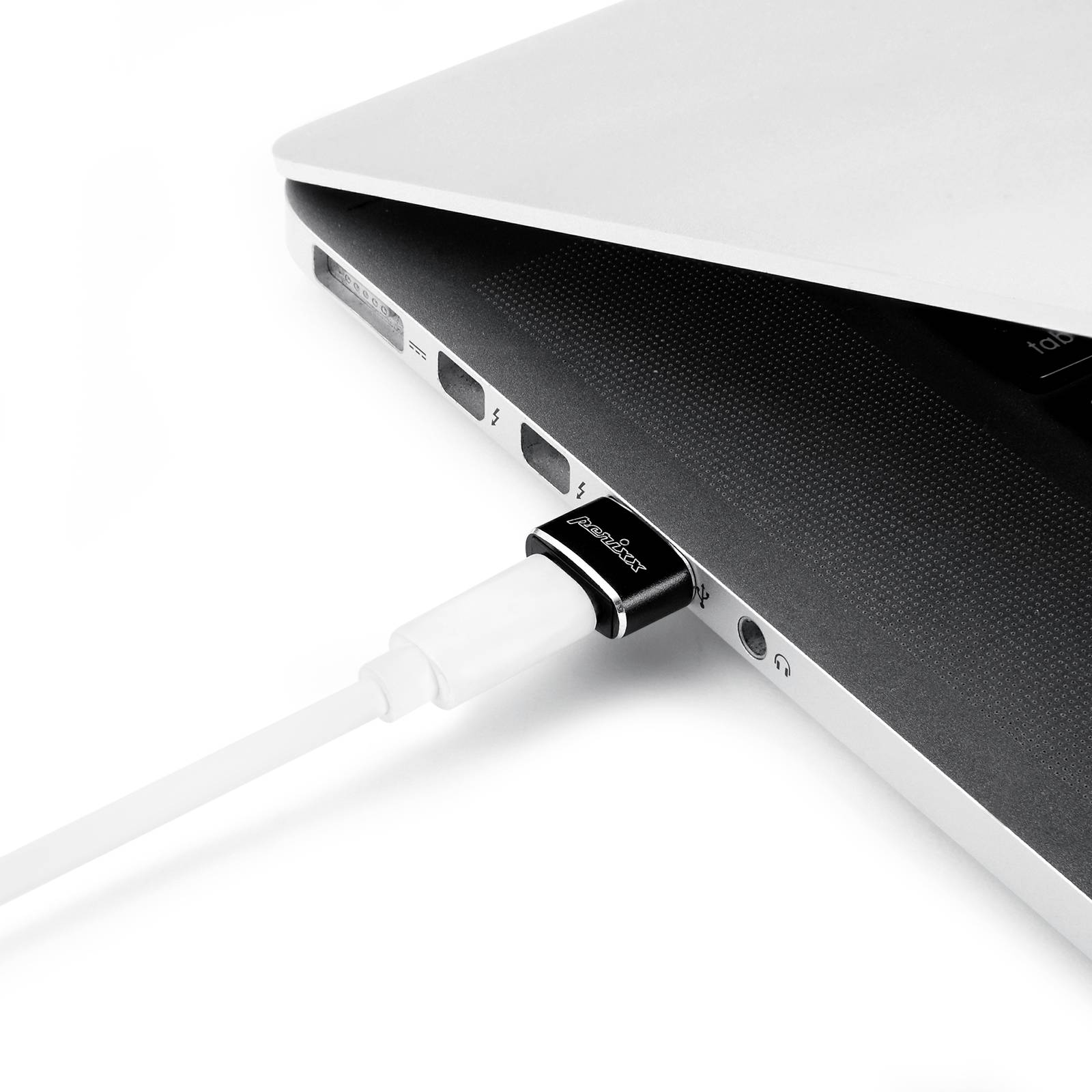 Notebook s nabíjecím kabelem zapojeným do jednoho z bočních USB portů. Notebook je částečně zavřený.