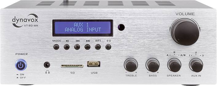 Stříbrný zesilovač 'dynavox' s digitálním displejem pro 'AUX 1 analogový vstup'; knoflíky pro hlasitost, basy a výšky.