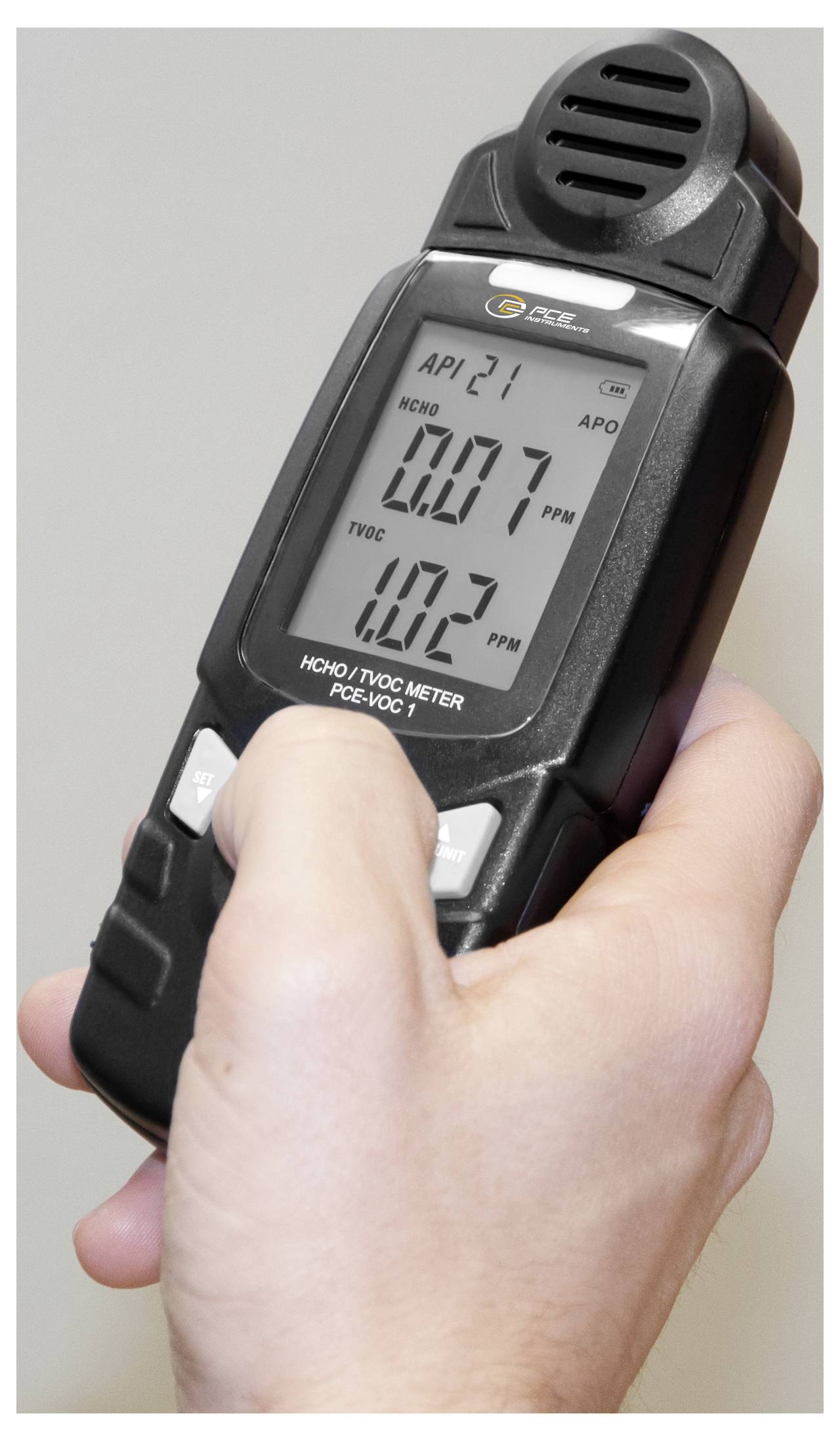 Ruční digitální měřič kvality vzduchu ukazující formaldehyd 0,07 ppm a TVOC 10,3 ppm v ruce osoby
