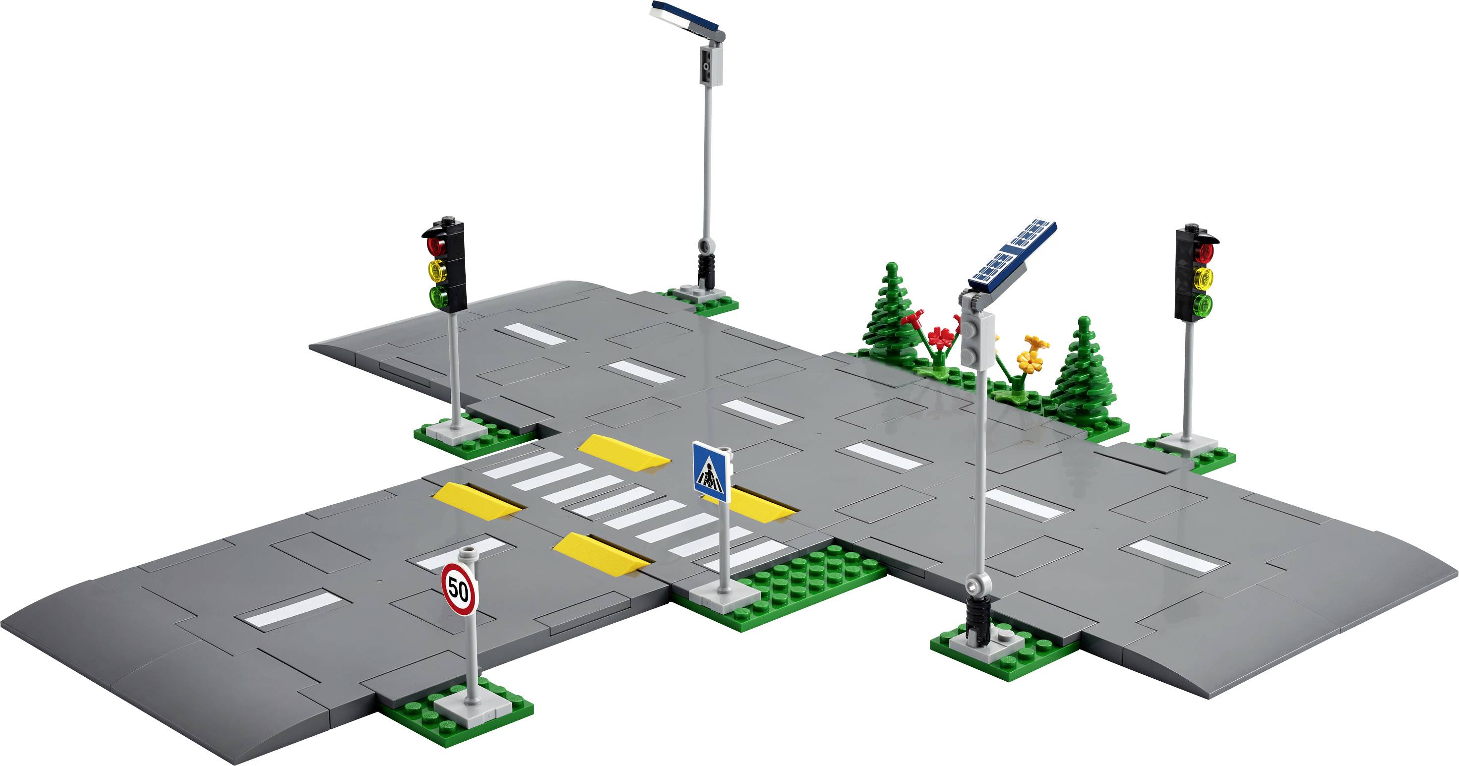 Křižovatka vytvořená z hraček, která zahrnuje přechod pro chodce, semafory, dopravní značku omezující rychlost (50 km/h) a informační cedule.