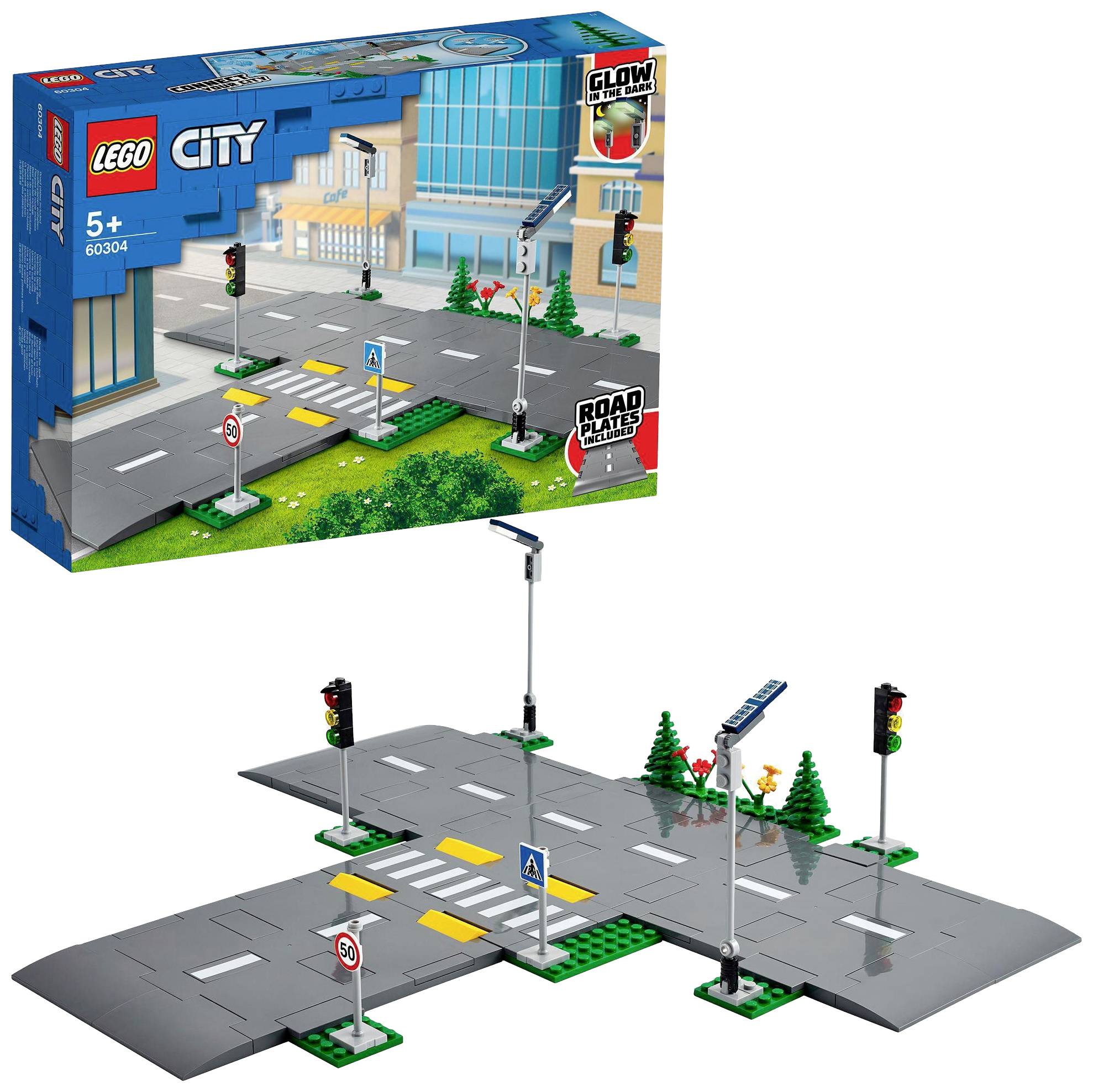 Sada hraček 'LEGO City' s díly silnic, semafory a dopravními značkami. Vhodné pro děti od 5 let. Balení v pozadí.