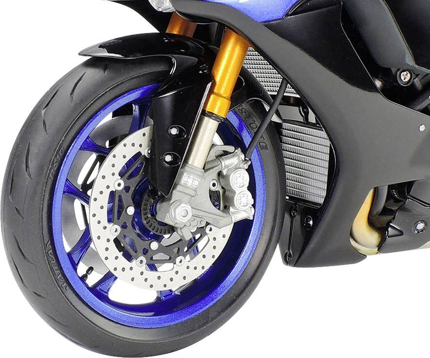 Detailní záběr předního kola motocyklu s modrou ráfkou a zlatým zavěšením. Brzdový kotouč a pneumatika jsou zřetelně viditelné.