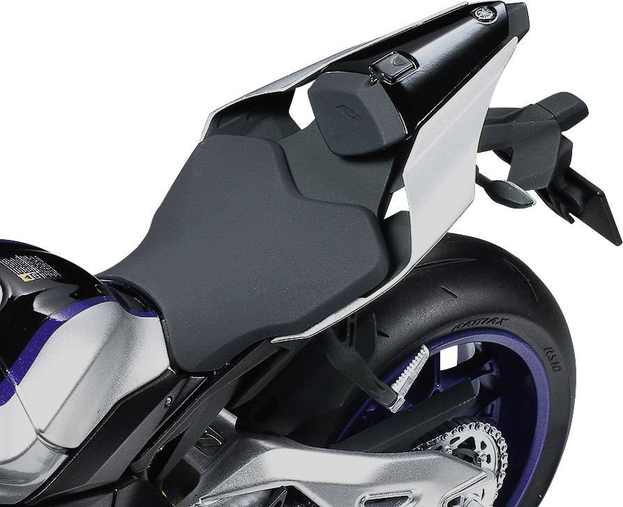 Detailní záběr motocyklu s moderním designem, zaměřený na sedlo a zadní kolo, odhalující technické a stylistické prvky.