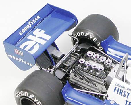 Modrý formule 1 závodní vůz s logy Goodyear a Elf na zadním křídle. Viditelný motor odhaluje složitou techniku.