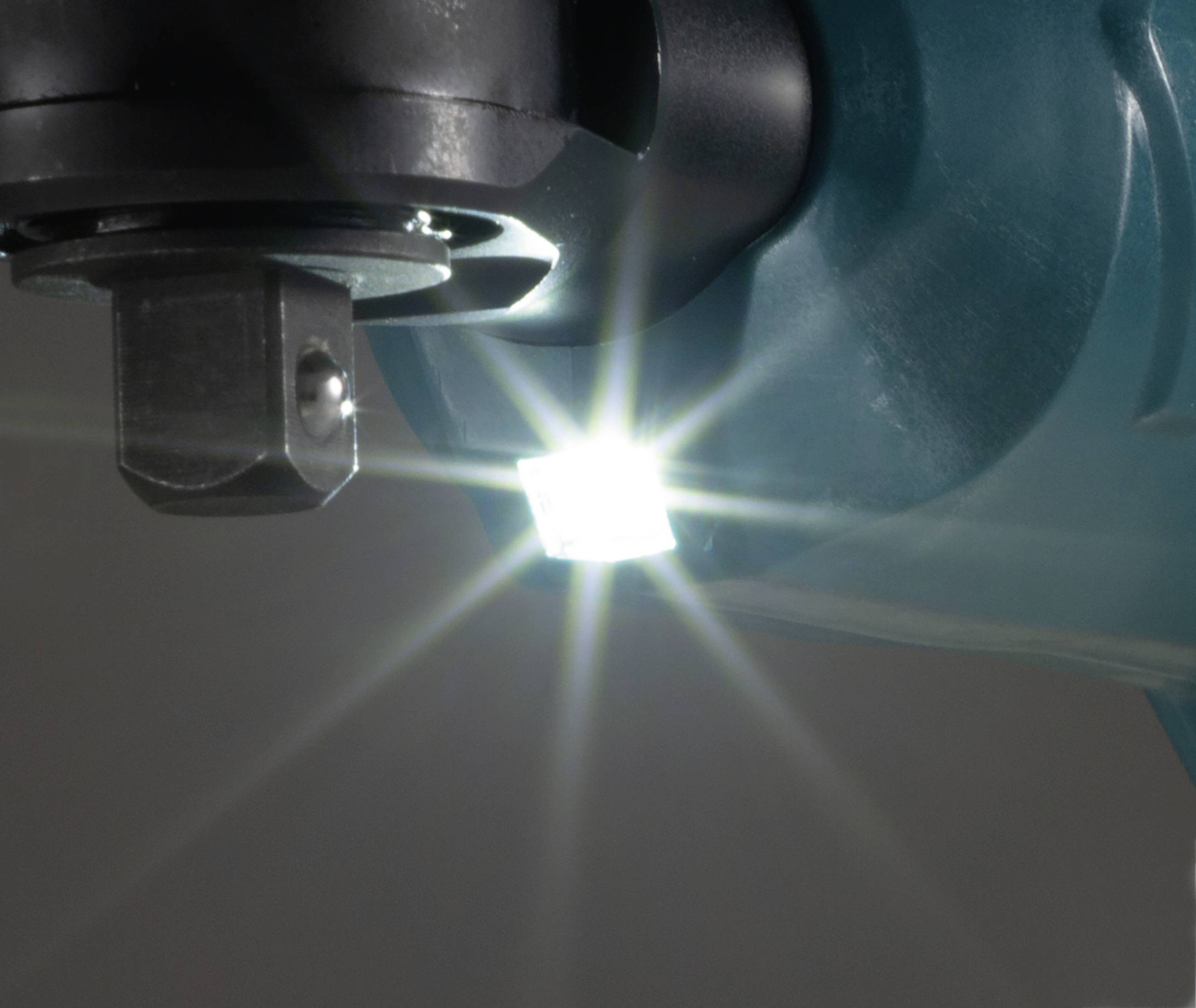Detailní záběr svítícího LED světla na mechanickém zařízení. Světlo jasně září dopředu a zvýrazňuje nástroj.