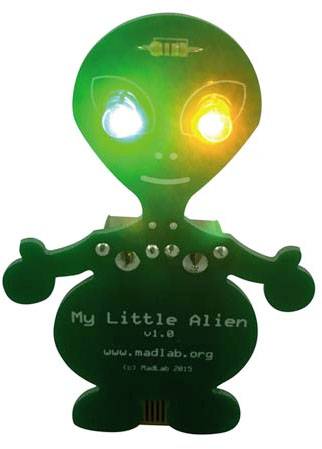 Malý zelený model mimozemšťana se svítícíma očima a nápisem 'My Little Alien v1.0'. Stojí na podstavci.