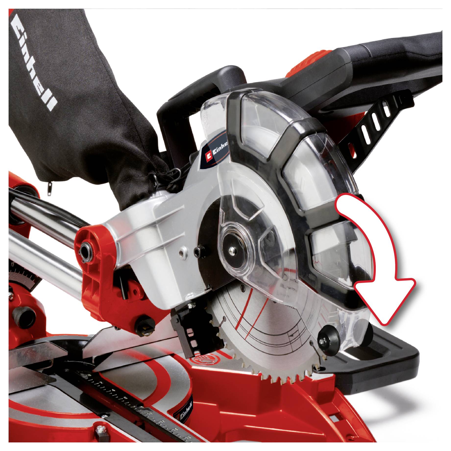 Detailní pohled na pilový kotouč pily se zkosením a ochranný kryt se červenou šipkou ukazující na oblast kotouče, což naznačuje, kde se podívat nebo provést úpravu.