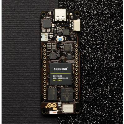 Detailní záběr černé Arduino desky s několika malými elektronickými komponenty a konektory, umístěné na černém povrchu.