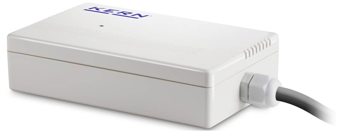Obdélníkové bílé elektronické zařízení s nápisem 'Kern'. Zařízení má kabelové připojení na pravé straně.