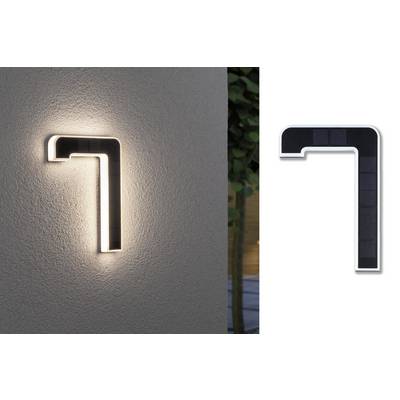 Svítící domovní číslo '7' namontované na zdi, vyrobené z černého materiálu s osvětlením. Vhodné pro venkovní použití a dobře viditelné ve tmě.