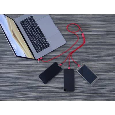 Laptop s třemi mobilními telefony propojenými červenými kabely. Zařízení leží na vzorovaném dřevěném stole.