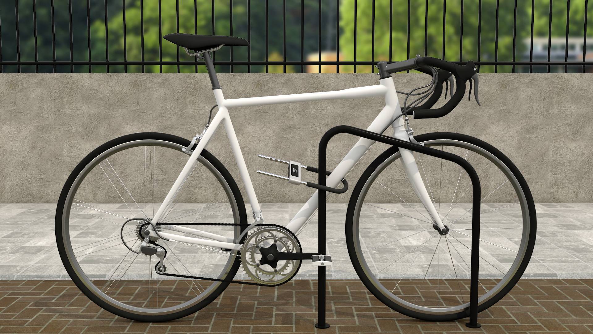 Bílé kolo je připoutané k kovovému stojanu na kola, v pozadí je zeď s rozmazanou zelenou krajinou.