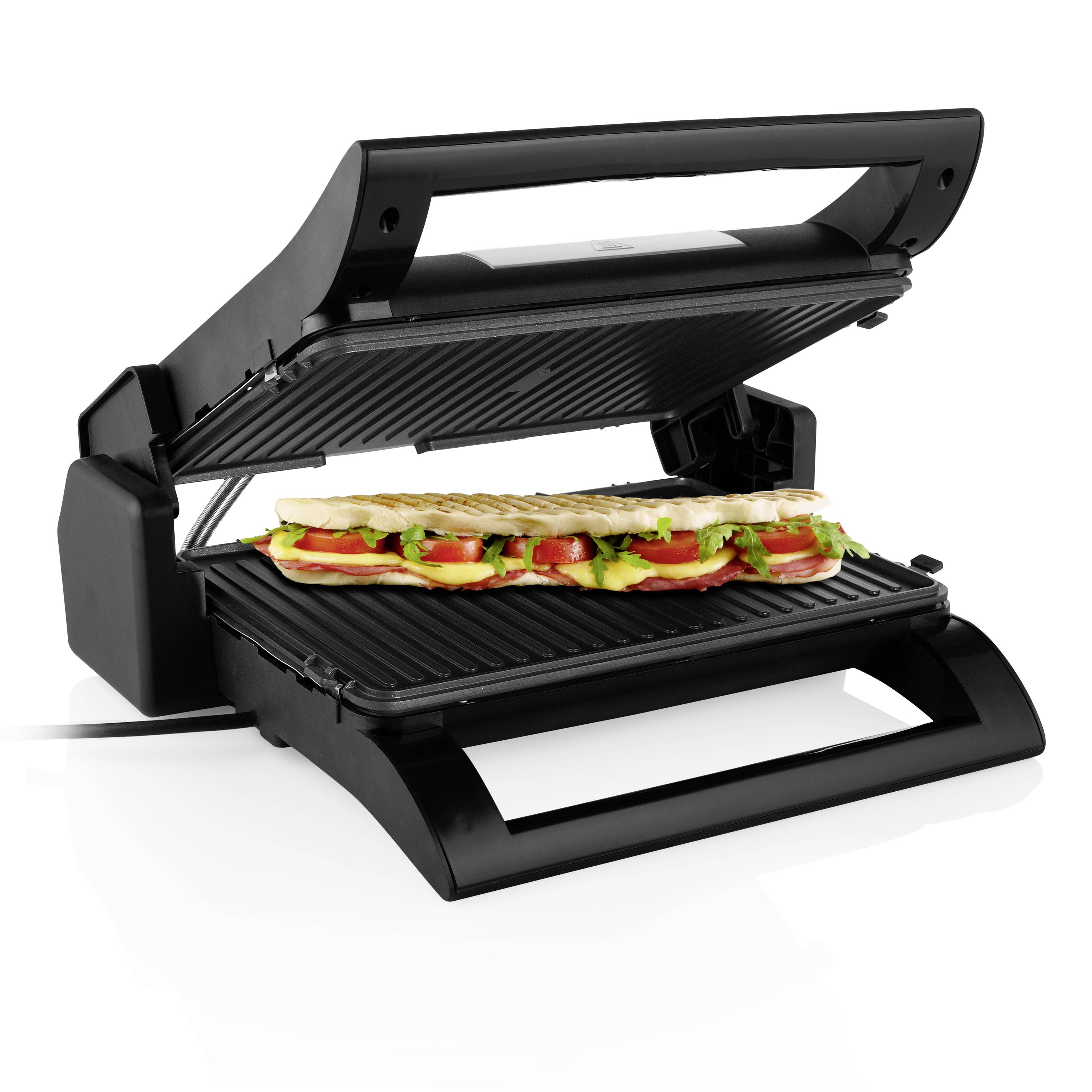 Černý kontaktní gril s otevřeným víkem. Na grilovací ploše leží panini se salátem a zeleninou.