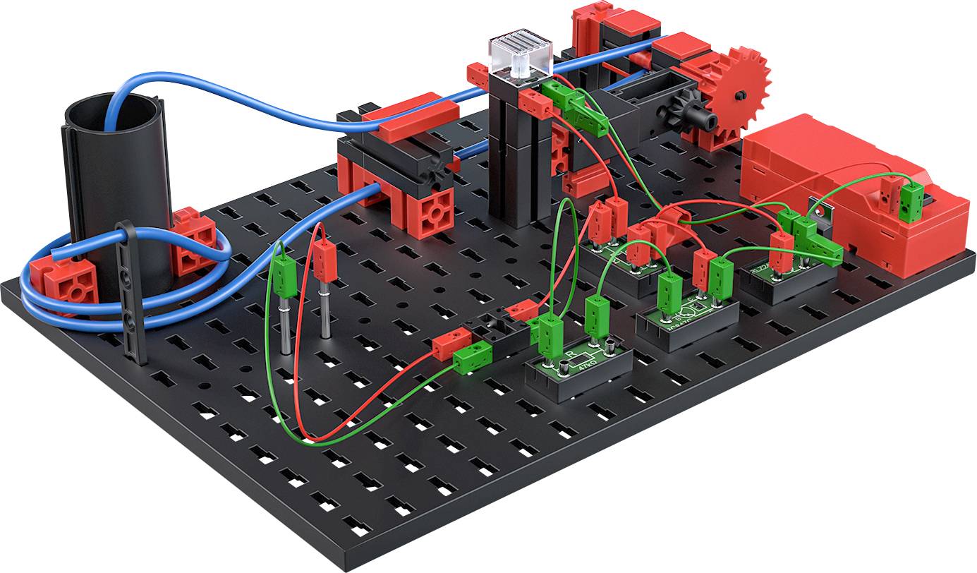Model elektrického obvodu stavebnicového typu s červenými a zelenými komponenty na černé desce. Vodiče propojují různé moduly.