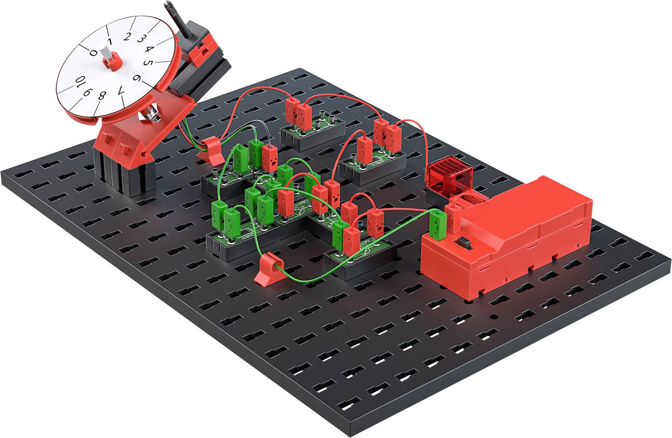 Elektronický stavebnicový obvod s různými zasunovacími komponenty na černé desce; červené a zelené propojovací prvky.