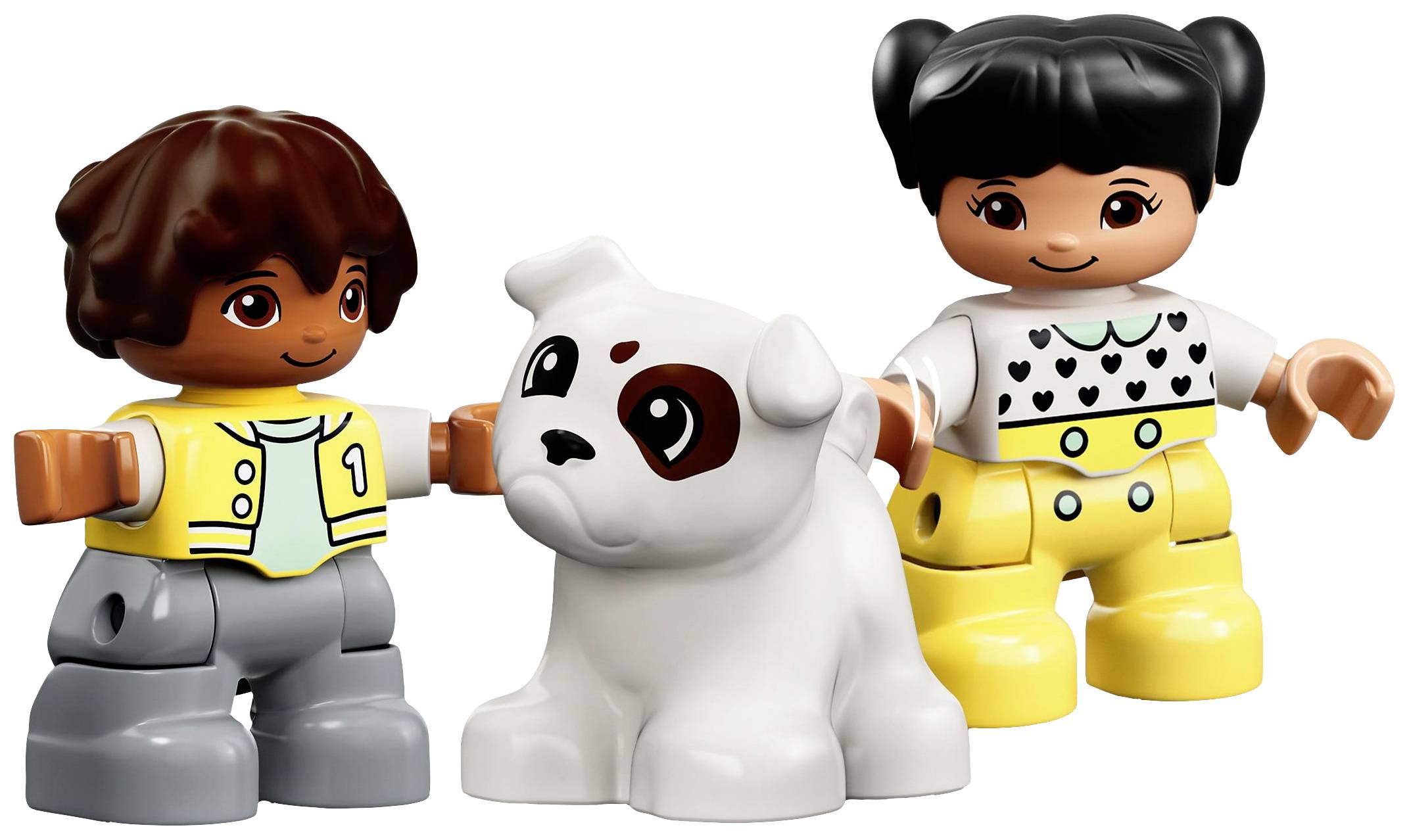 Dva usmívající se LEGO-Duplo panáčci, chlapec a dívka, si hrají s bílým psem s hnědými skvrnami. Vypadají šťastně.