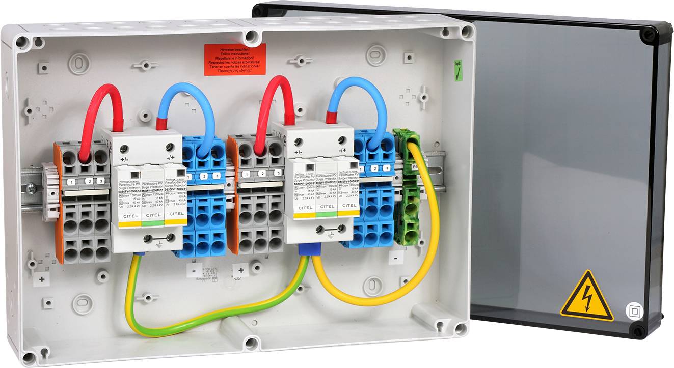 Otevřená rozvodná skříň s barevnými vodiči, elektrickými komponenty a výstražným symbolem elektrického napětí.