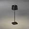 Černá stolní lampa s čtvercovým stínidlem na šedém pozadí. Difuzní světlo dopadá dolů. Moderní, minimalistický design.