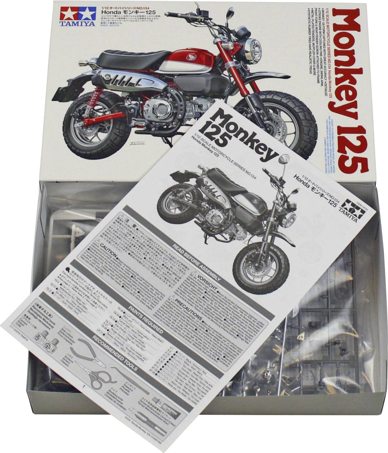 Stavebnice modelu motocyklu 'Honda Monkey 125' od firmy Tamiya. Otevřená krabice zobrazuje návod a díly modelu určené pro sestavení miniaturního motocyklu.