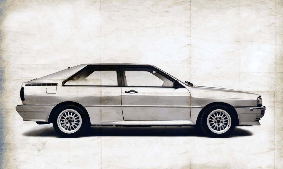 Klasický automobil z profilu, veterán s hranatým designem na zestárlém pozadí. Drátěná kola zvýrazňují retro vzhled.