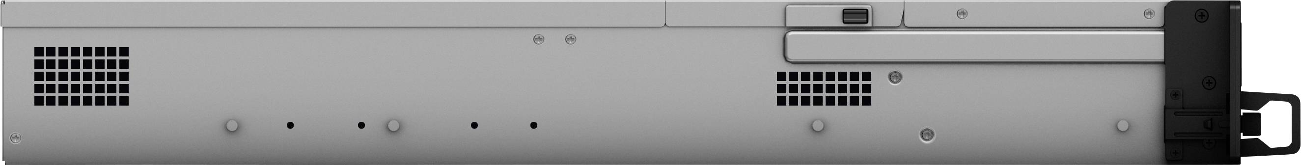 Stříbrná, obdélníková schránka s větracími štěrbinami a černou rukojetí na pravé straně. Technický pohled zezadu.