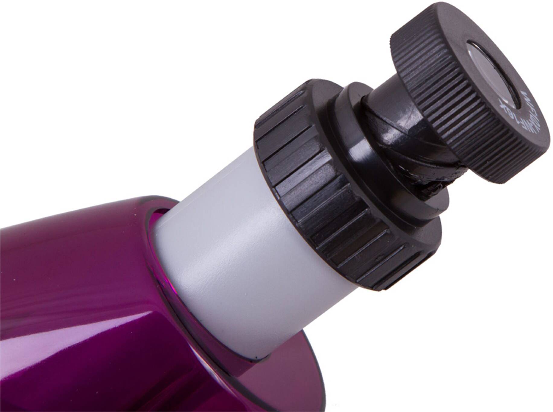 Detailní záběr fialového a černého víčka, pravděpodobně z kosmetického výrobku, s otočným uzavíracím mechanismem.
