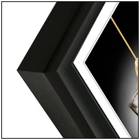 Detailní záběr černého rohu obrazového rámu, který se diagonálně svažuje s akcentní linkou. Pozadí je jednoduché.