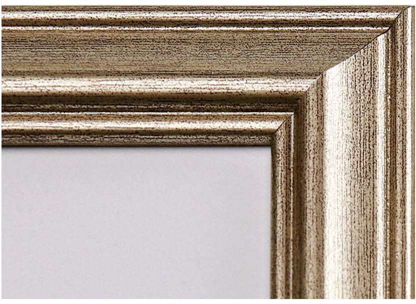 Dřevěný rám s jemnou kresbou dřeva v hnědém tónu. Pravoúhlá hrana odhaluje detail a texturu rámu. Stříbřitý odlesk.