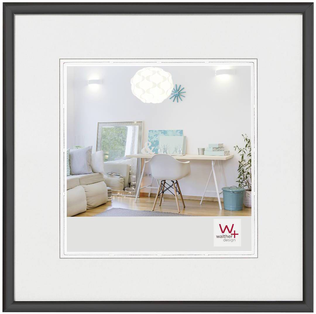 Interiér domu s jasným, moderním pracovním prostorem: psací stůl, židle, odpočinkový prostor s pohovkou a lampa. Barva stěn je bílá.