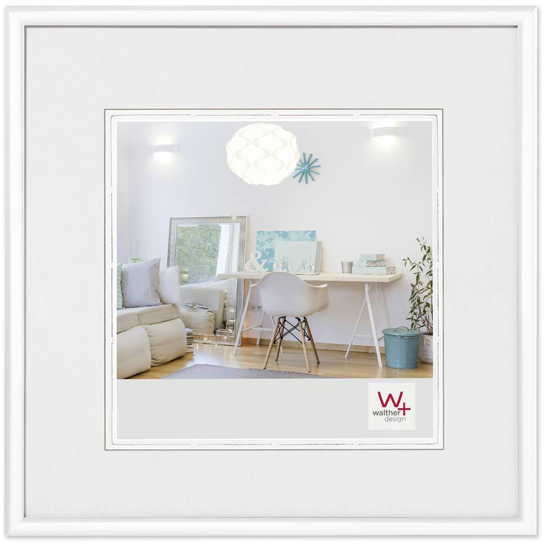 Světlý, moderní prostor s bílým stolem, na němž leží umělecké materiály a dekorace. Vlevo sedačka, nahoře závěsné svítidlo.