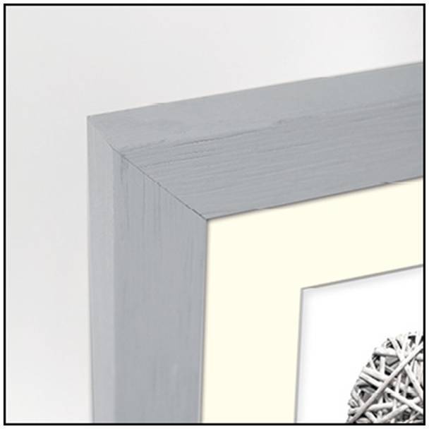 Detailní záběr rohu šedého rámu s částí zarámovaného obrazu.