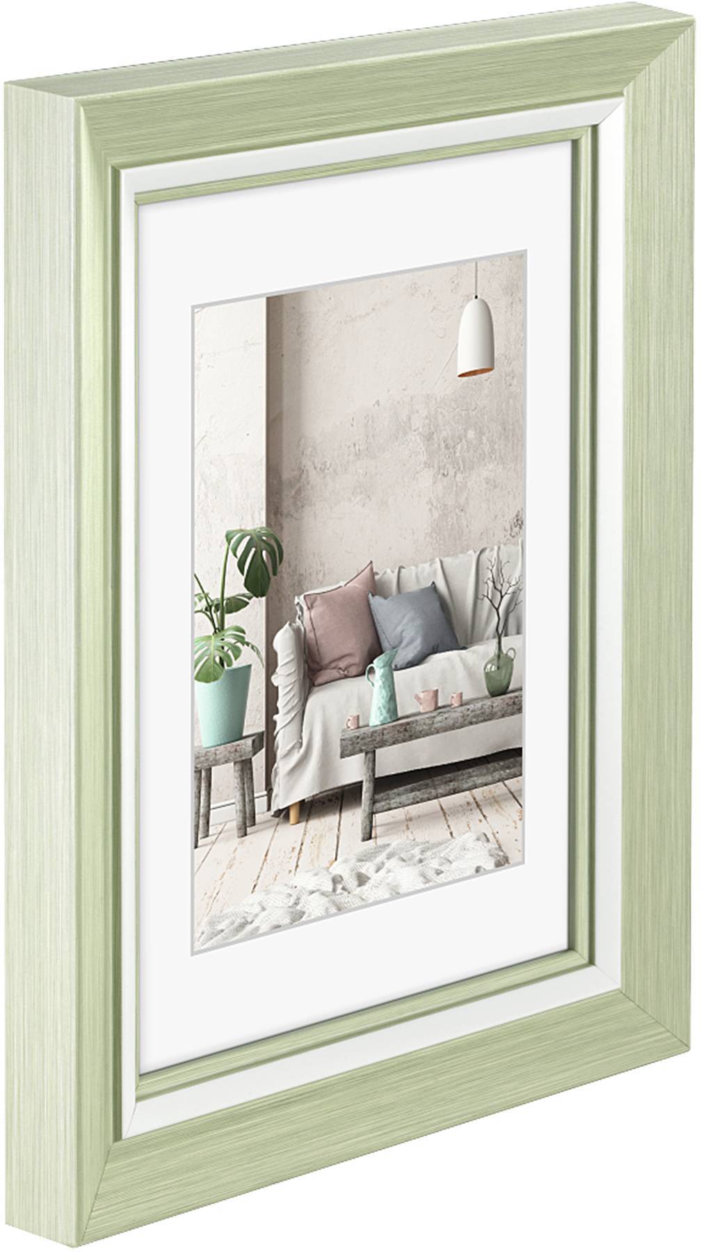 Zarámovaný obraz moderního obývacího pokoje s pohovkou, dekorativními polštáři, rostlinami a závěsnou lampou. Prostor dominují pastelové barvy.