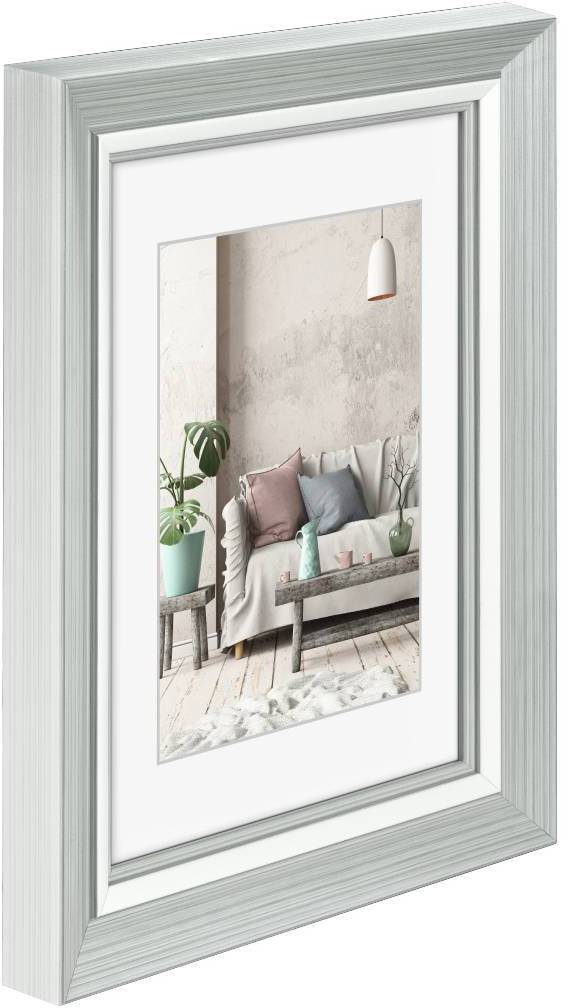 Zarámovaný obraz moderního obývacího pokoje se sedačkou, polštáři a rostlinou, který ukazuje útulné zařízení a jemné barevné ladění.