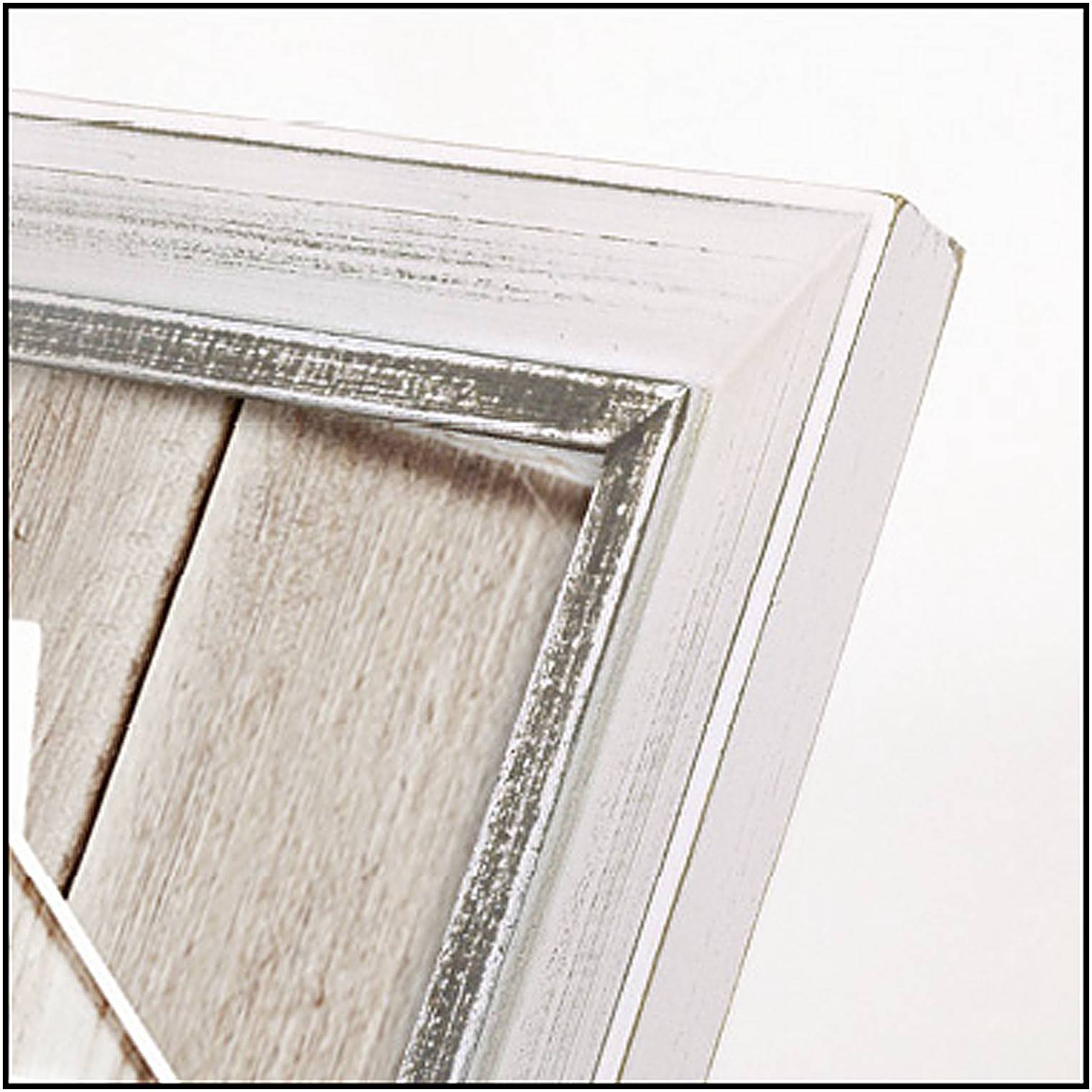 Bílý, mírně opotřebovaný dřevěný fotorámeček, který lemuje roh fotografie. Obrázek vykazuje rustikální estetiku.