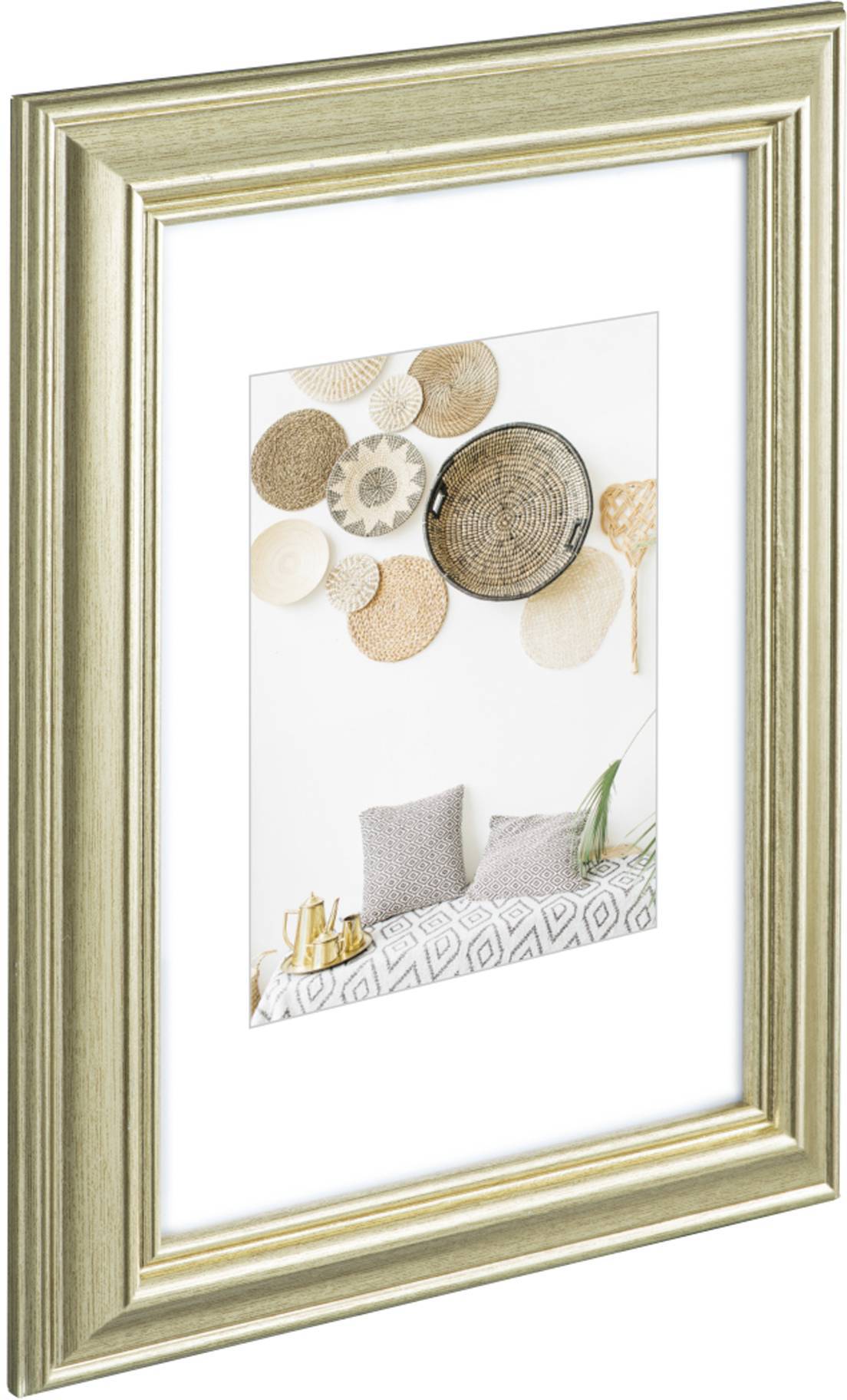 Nástěnná dekorace s košíky nad pohovkou s polštáři, zasazená ve zlatém rámu.