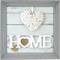 Zarámovaný obraz ukazuje srdce z bílého propletence nad slovem 'HOME' napsaným bílými písmeny na světle modrém pozadí.