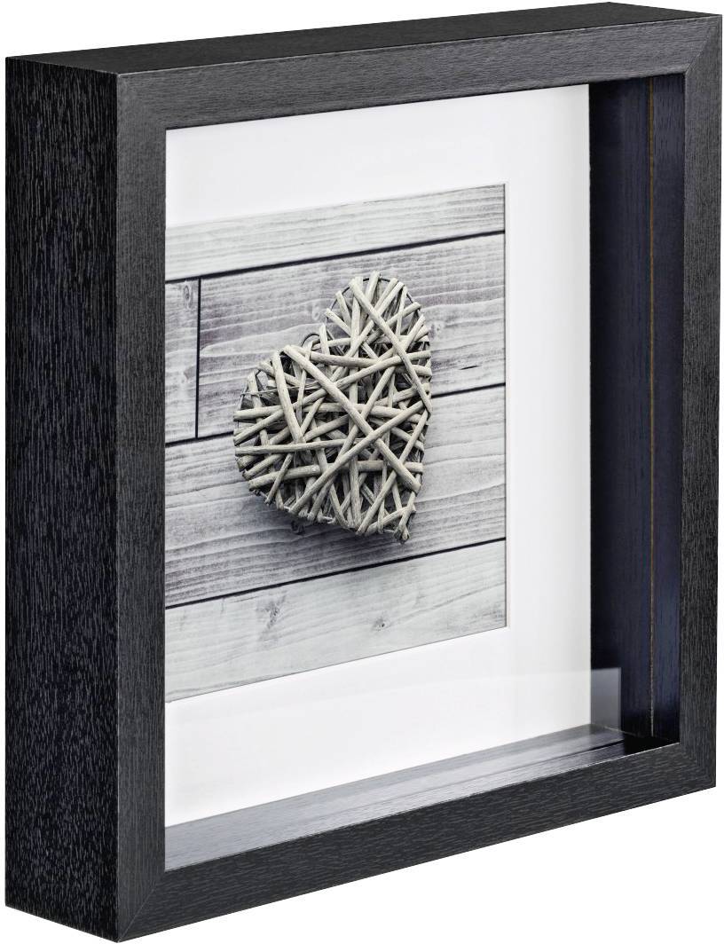 Zarámovaný obraz zobrazuje srdce z propletených větví na pozadí dřevěných prken. Rám je černý a hluboký.