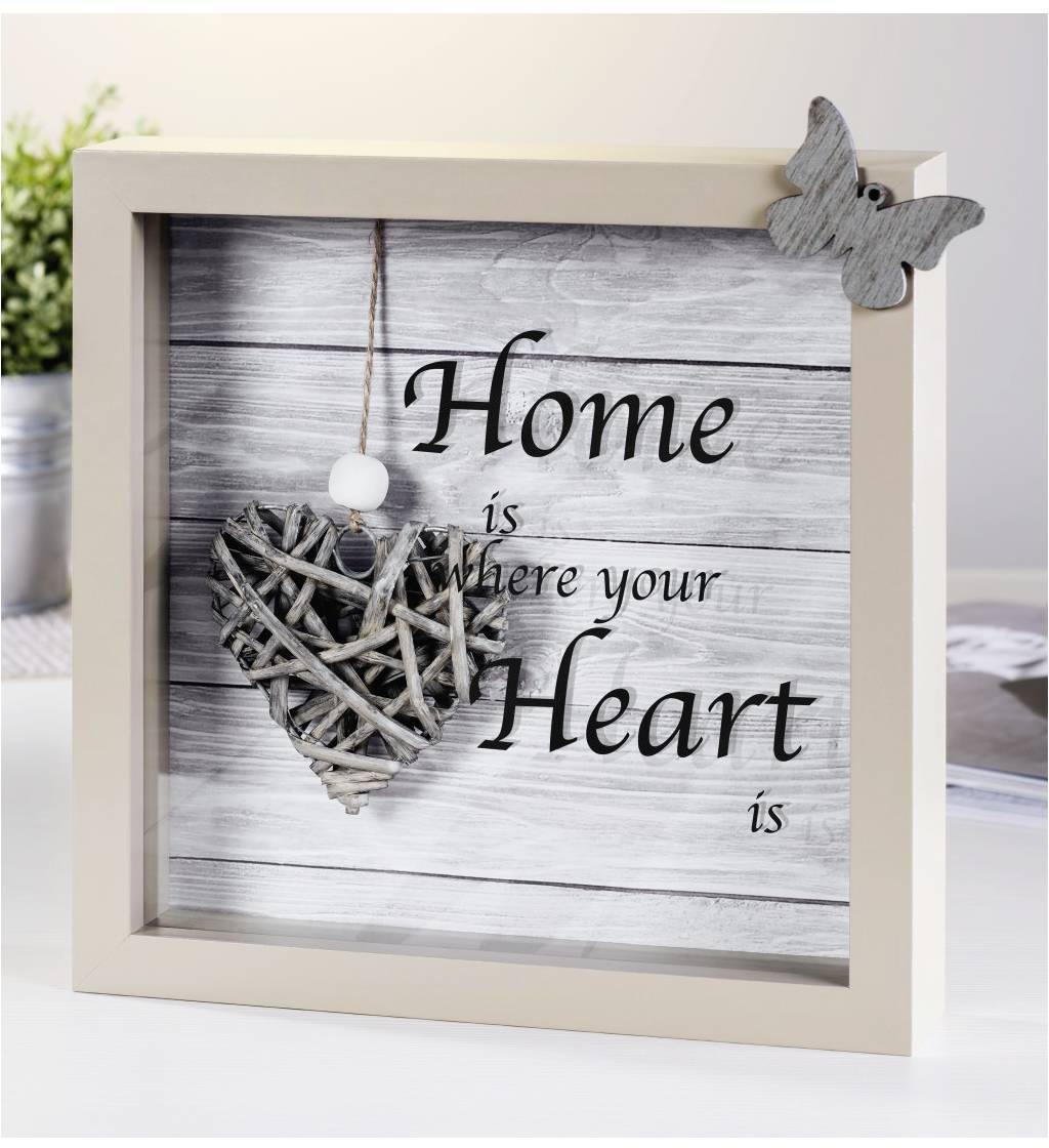 Rámeček s srdíčkovým ornamentem vytvořeným z větví a citátem "Domov je tam, kde je tvé srdce" na dřevěném pozadí.
