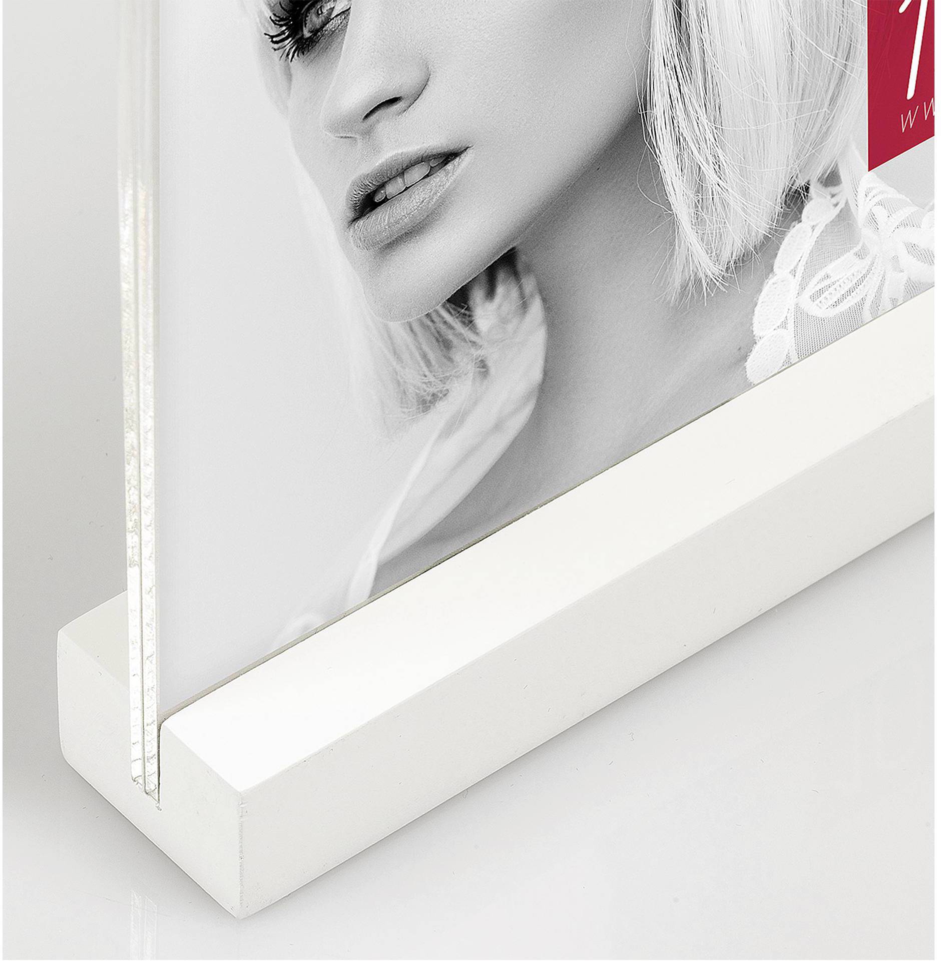 Moderní akrylový fotorámečk s portrétem ženy oblečené v elegantním bílém oděvu. Displej má stabilní bílou základnu.