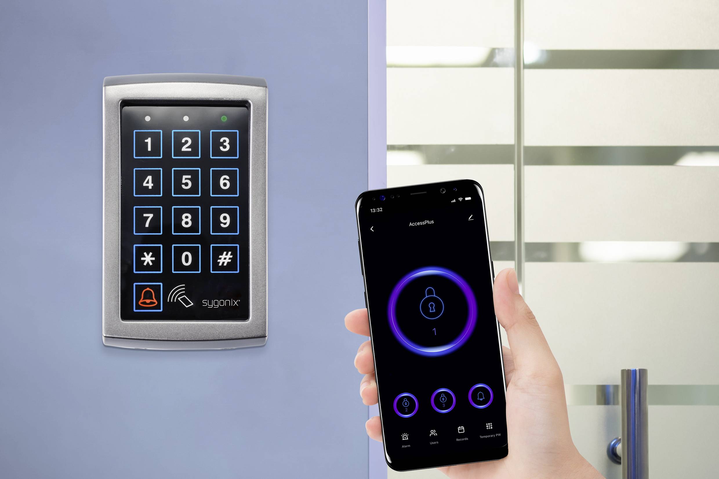 Jedna ruka drží smartphone s odemčenou aplikací poblíž přístupového kontrolního panelu s klávesnicí a RFID čtečkou.
