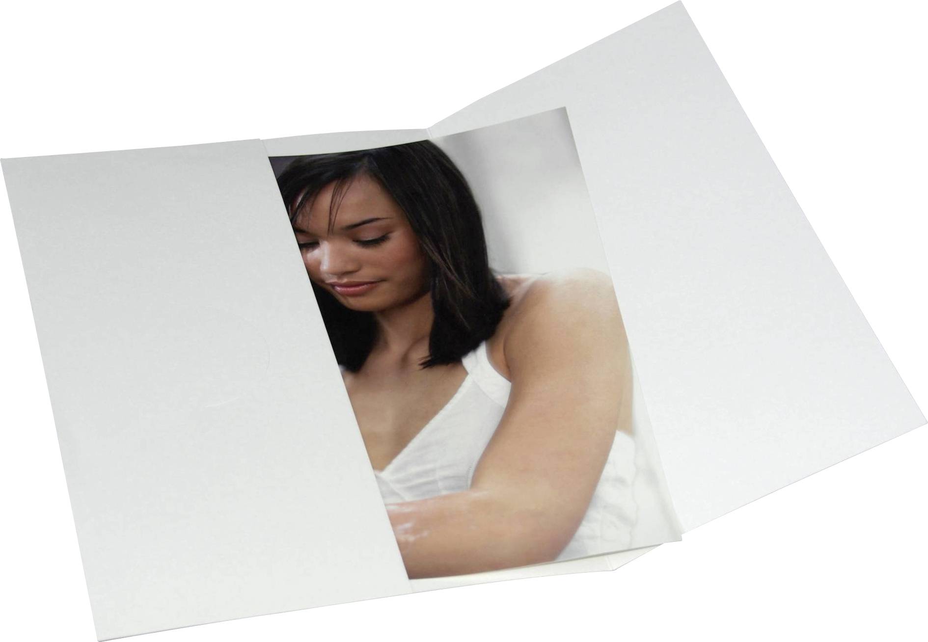 Žena v bílém topu se zavřenýma očima, lehce se usmívající, na z poloviny otevřeném fotografickém tisku na bílém pozadí.