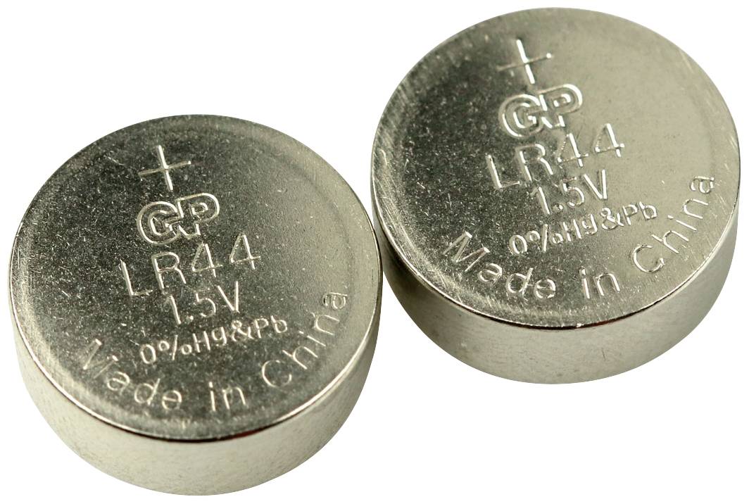 Dvě stříbrné knoflíkové baterie GP LR44 1,5 V položené na sobě; na povrchu jsou vytištěny znaménka plus a "Made in China".