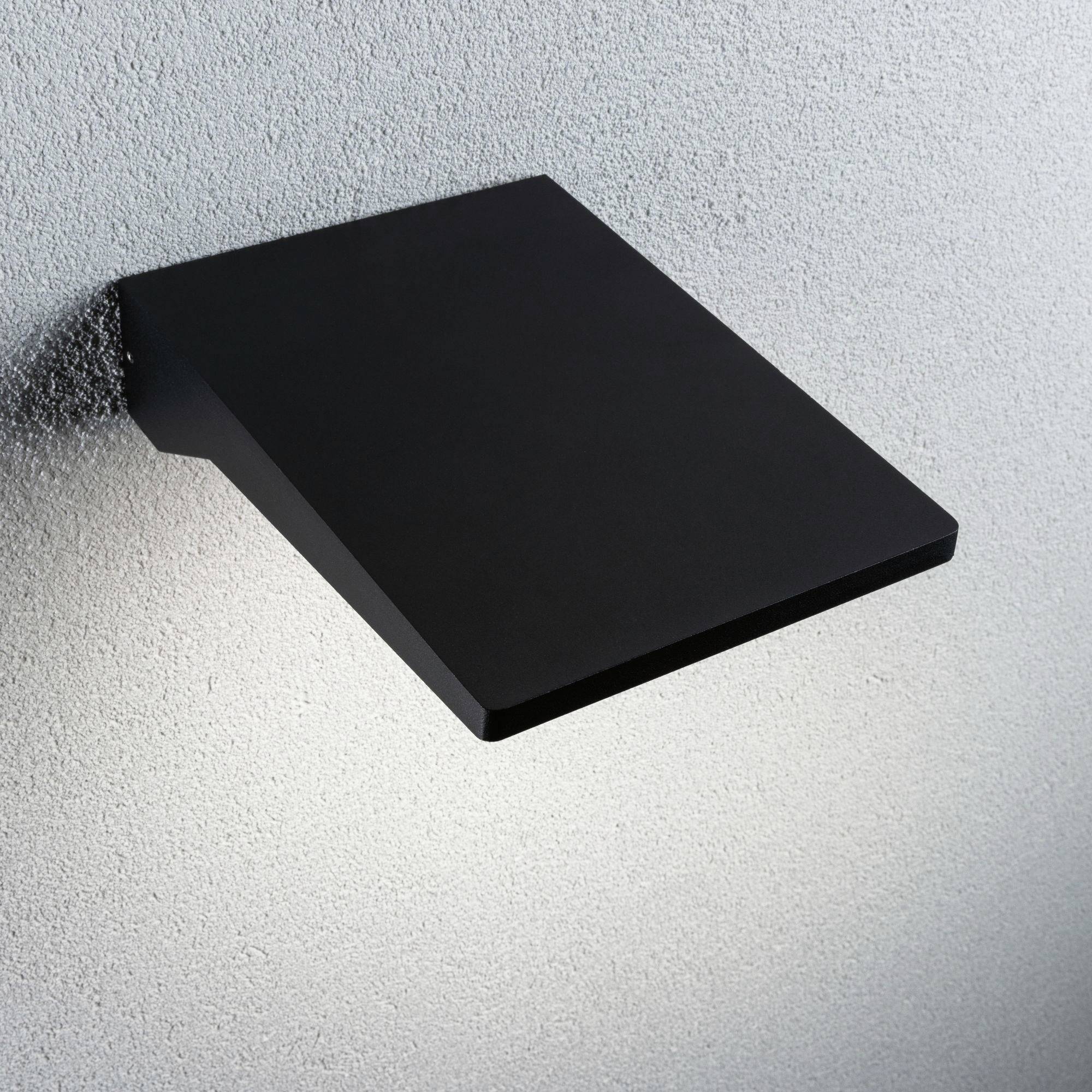 Černé nástěnné LED svítidlo osvětluje šedou stěnu. Minimalistický design. Rovnoměrné rozptýlení světla.