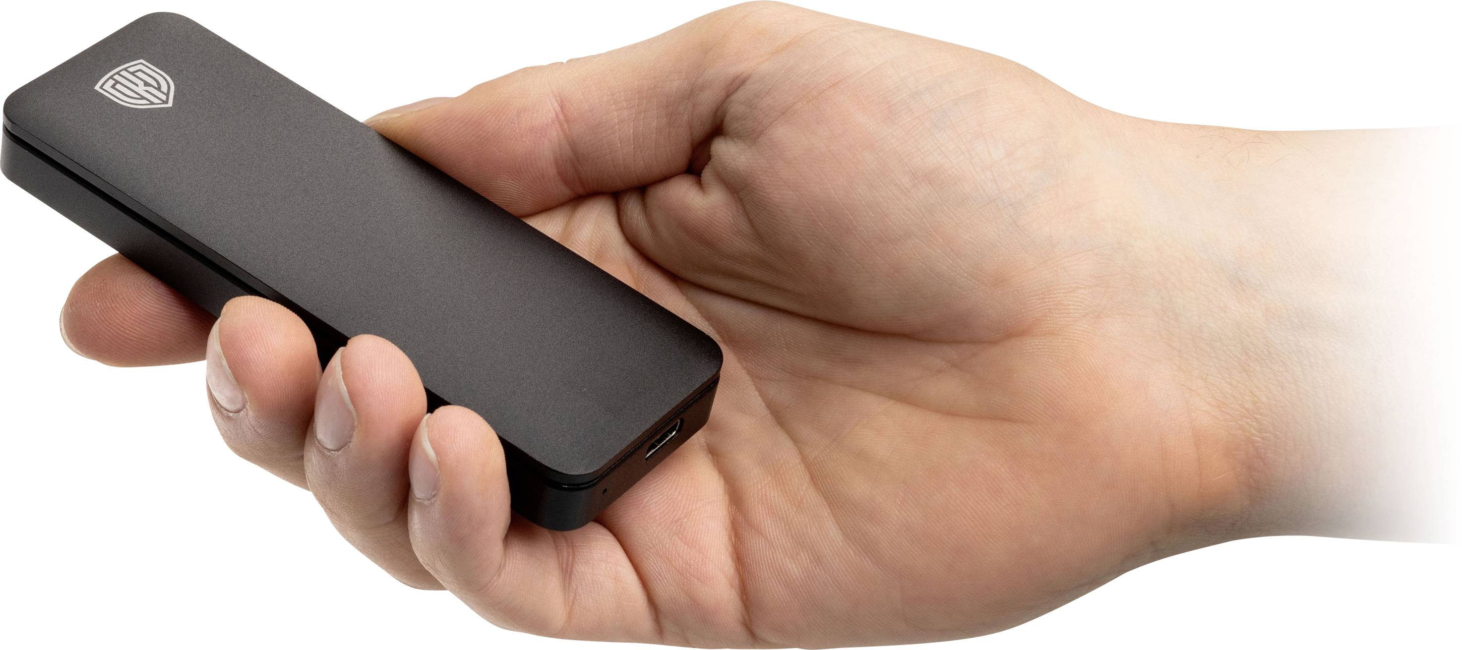 Jedna ruka drží štíhlé, černé elektronické zařízení, podobné externí harddisku nebo USB disku.