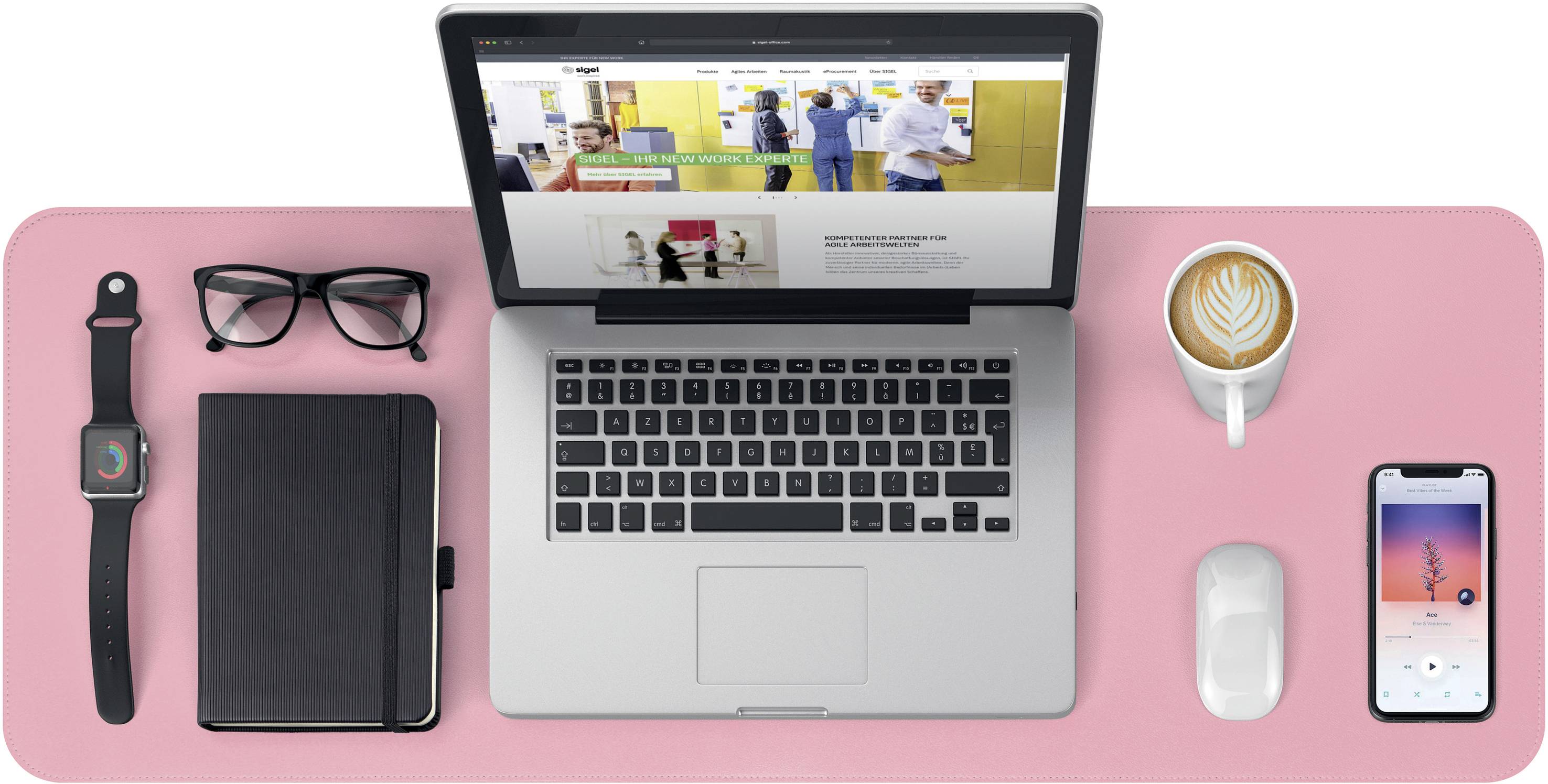 Laptop na růžovém psacím stole, obklopený brýlemi, chytrými hodinkami, poznámkovým blokem, šálkem kávy a smartphonem.