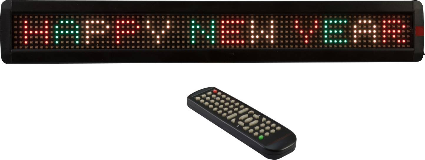 LED displej zobrazuje zprávu 'HAPPY NEW YEAR' červenými a zelenými písmeny. Před ním leží dálkový ovladač.