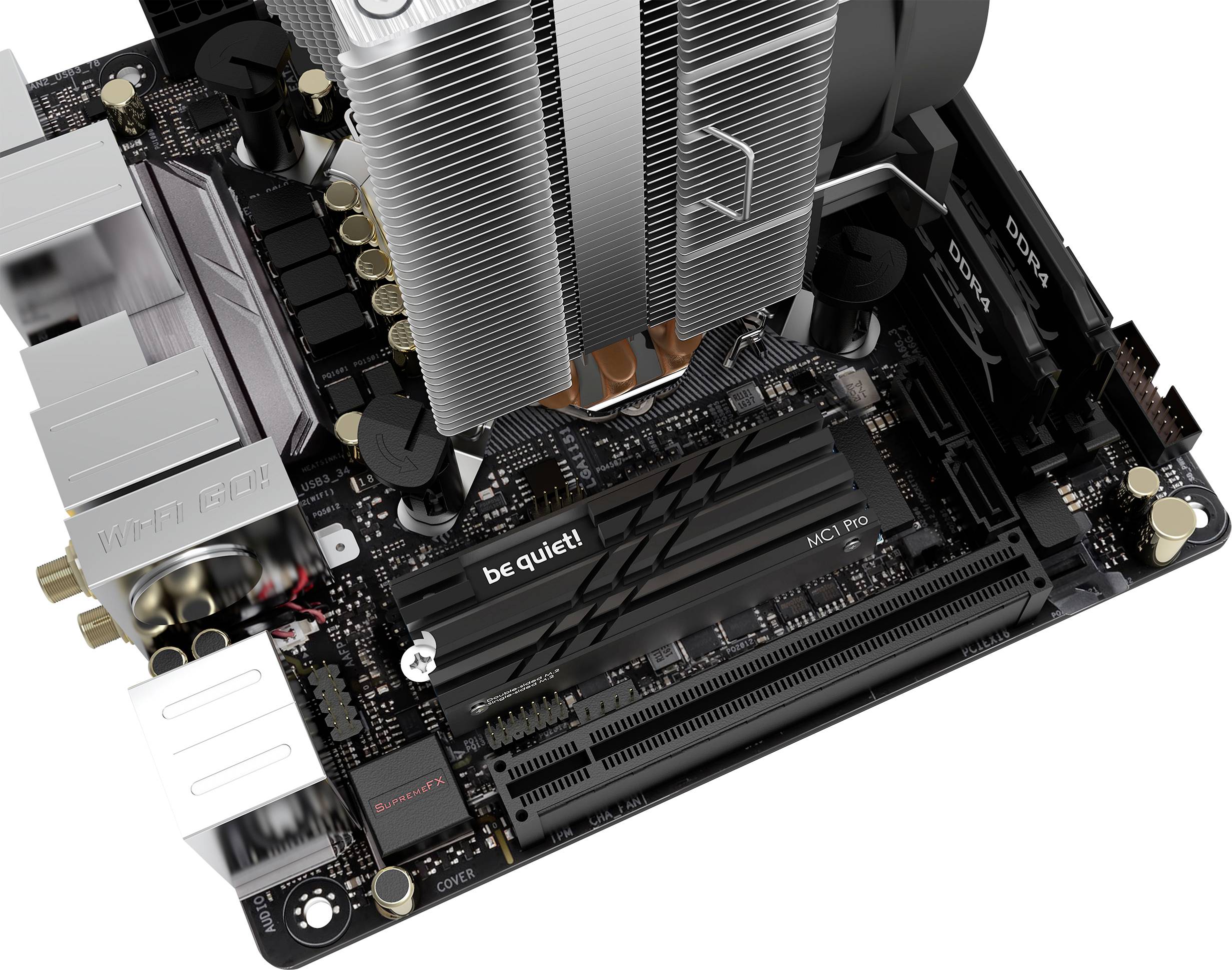 Základní deska s počítačovými komponenty, včetně chladiče CPU, slotu RAM a různých portů, částečně označených štítkem 'be quiet!'.